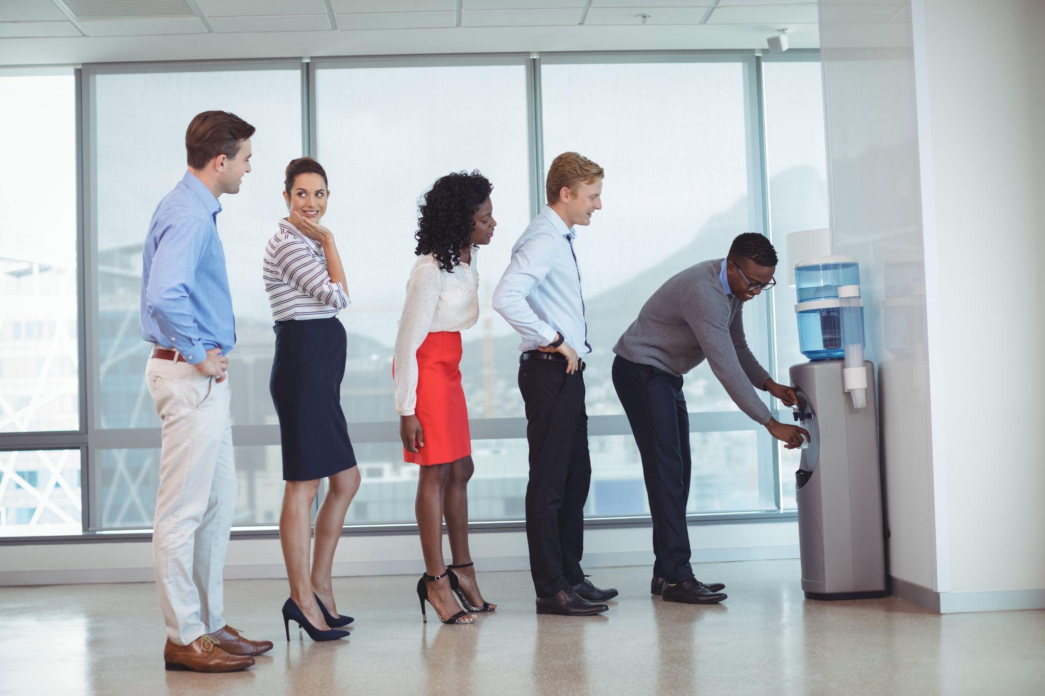 Office employees using a water cooler