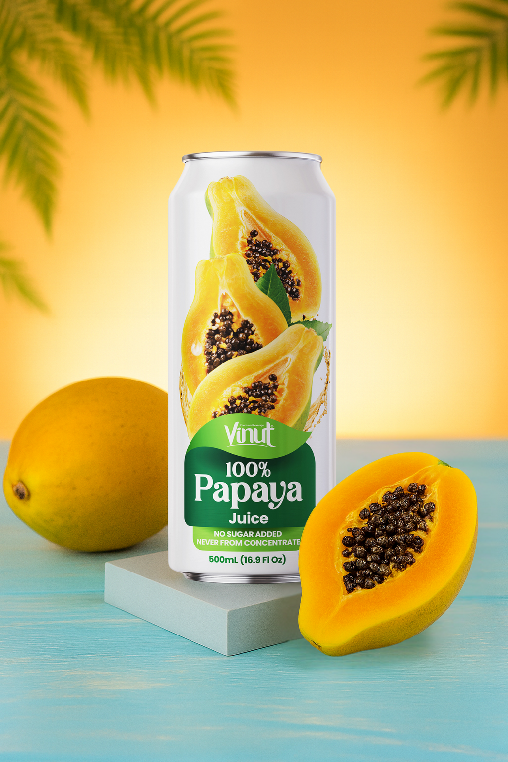 F_15 A can of Vinut 100% Papaya Juice is displayed with a whole papaya and a sliced papaya on a blue surface, against a yellow-orange background with palm leaves.