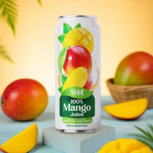 A can of Vinut 100% Mango Juice is displayed on a pedestal, surrounded by fresh mangoes and mango slices on a blue surface, with leaves and a basket in the background.