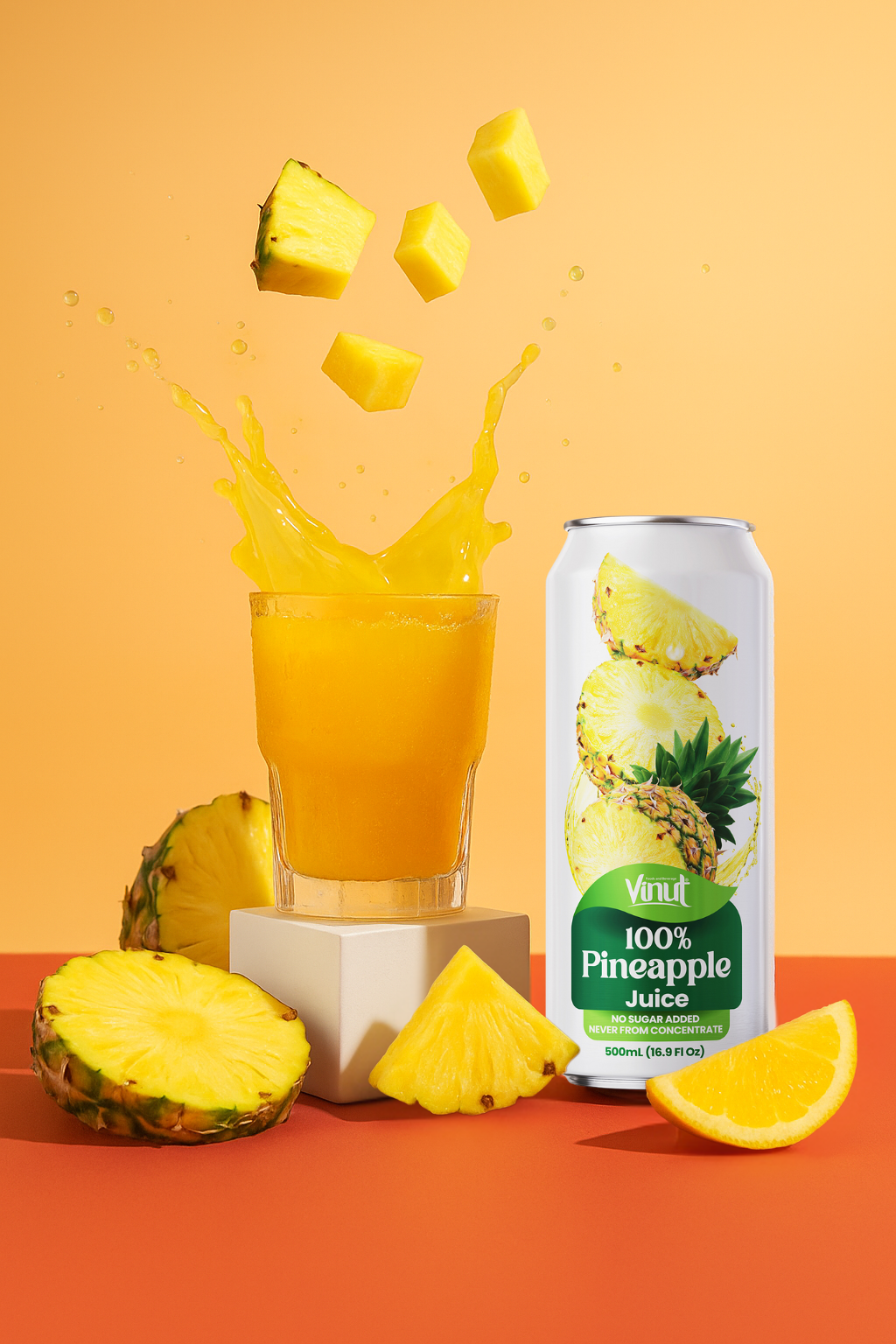 Untitled_design_-_2025-10-01T230139.289 A glass of pineapple juice splashes with pineapple cubes above, next to a can labeled "100% Pineapple Juice" and fresh pineapple slices on an orange background.